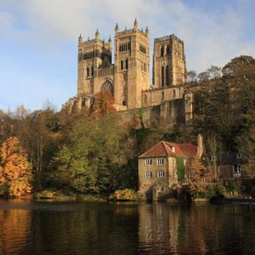 Large historic brick castle on a hill by the river