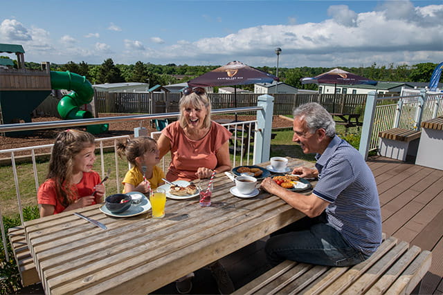 A family enjoying an al fresco meal at Crimdon Dene Holiday Park