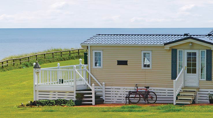 A lodge with a veranda on the seafront at Crimdon Dene Holiday Park