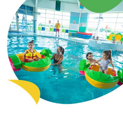 A family playing on Aqua Paddlers in the indoor swimming pool at Crimdon Dene Holiday Park