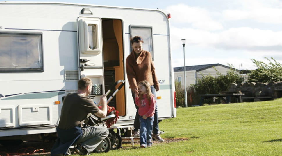 A family exiting their touring caravan at Eyemouth Holiday Park