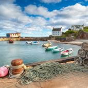 Pier with boats in water near beach