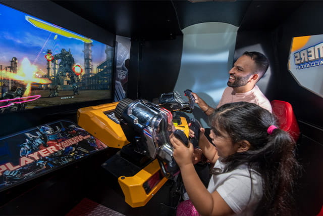 Father and daughter playing a shooting arcade game at Eyemouth Holiday Park