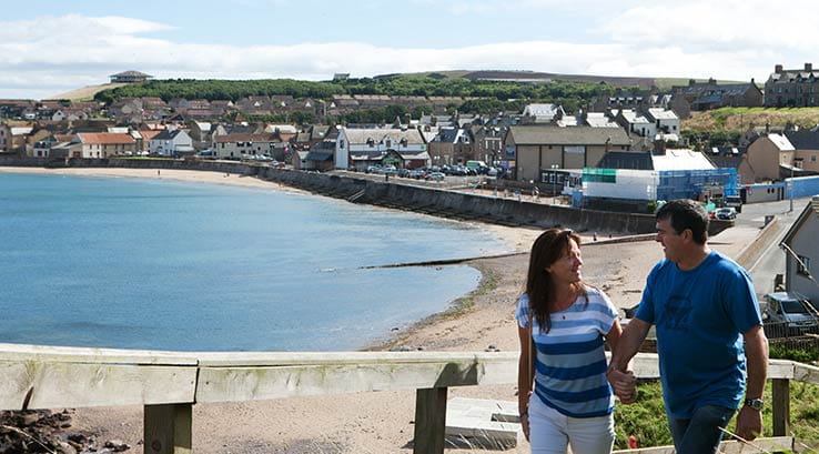 A couple strolling up towards the cliffs at Eyemouth Beach