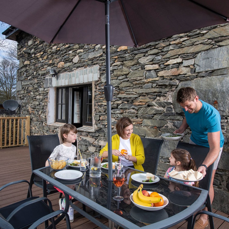A family enjoying a meal on their cottage veranda