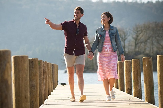 A couple strolling along the jetty near Fallbarrow Holiday Park at Lake Windermere