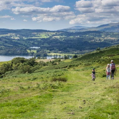 Stunning views of a family walking in vast green hills