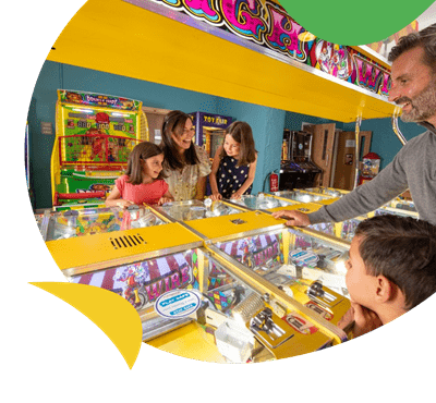 A family playing in the amusement arcade at Fallbarrow Holiday Park Lake District