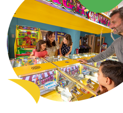 A family playing in the amusement arcade at Fallbarrow Holiday Park Lake District