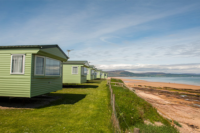 A row of caravans on a cliff top looking out to sea at Grannie's Heilan Hame Holiday Park