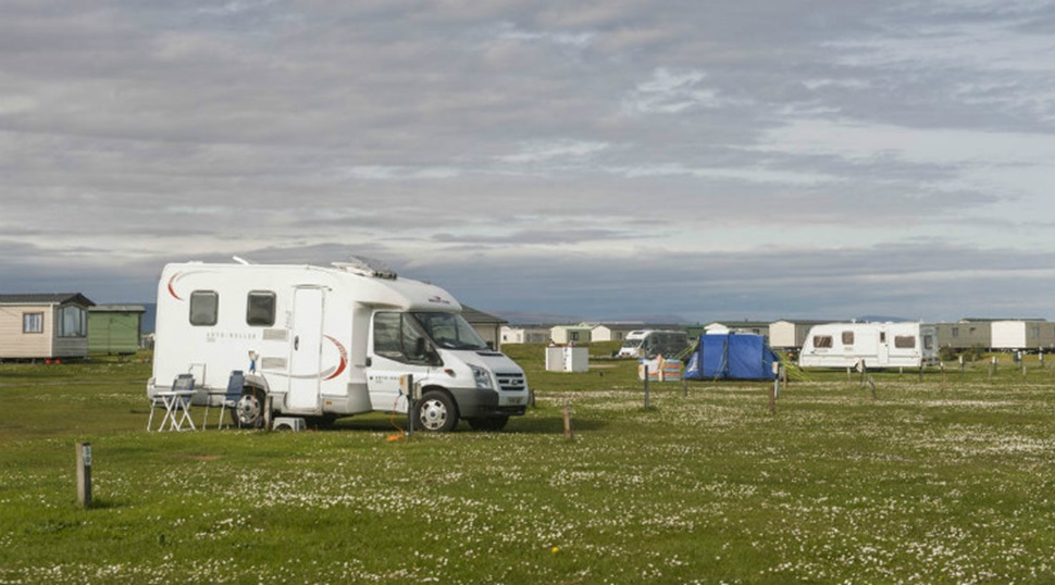 Motorhomes and touring caravans pitched up on the grass at Grannie's Heilan' Hame Holiday Park