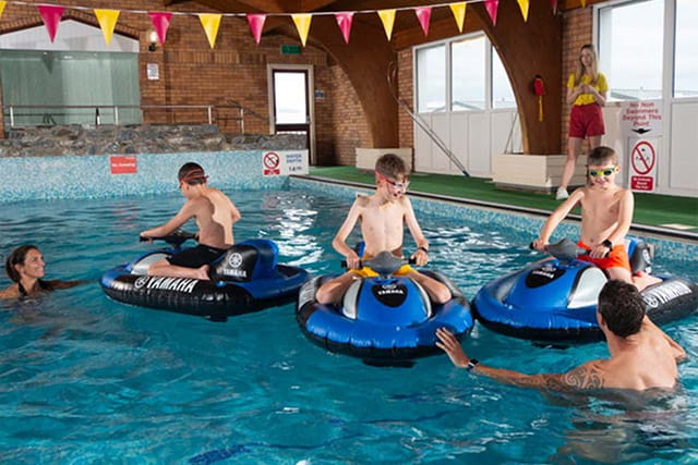 A family playing in the indoor swimming pool at Grannie's Heilan' Hame Holiday Park