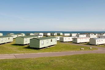 Rows of caravan accommodation sitting on green fields