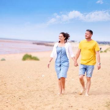 a couple going for a beach walk