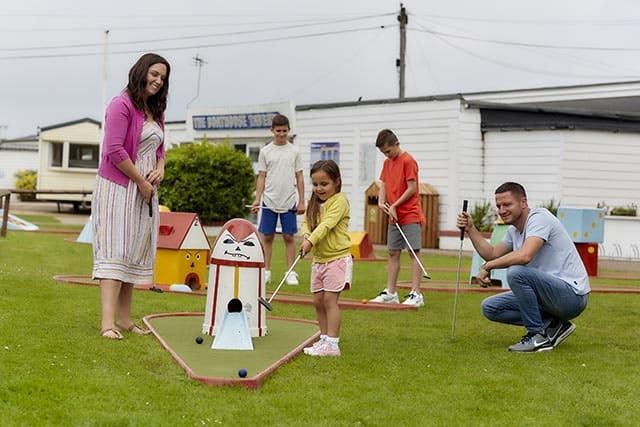 Family playing mini golf at Heacham Beach Holiday Park