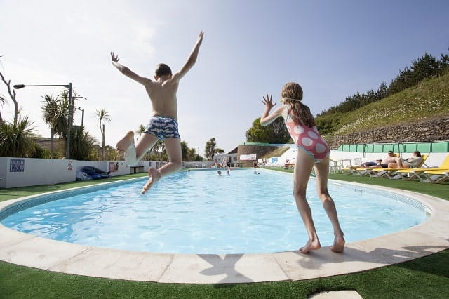 child sliding down a water flume