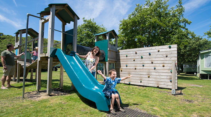 Kids enjoying outdoor slide on the park at Holywell Bay