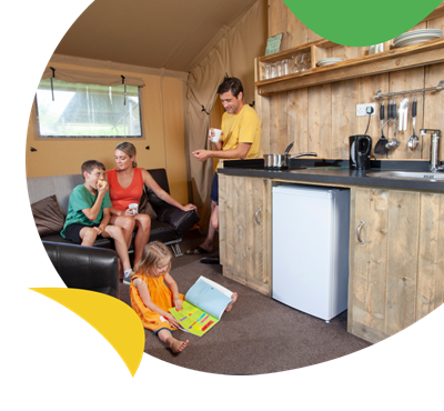A family relaxing in a glamping tent at Holywell Bay Holiday Park