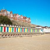 A Seaside town with beach and beach huts in the foreground