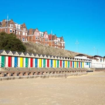A Seaside town with beach and beach huts in the foreground