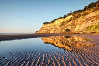 A coastal cliff reflected in the sea