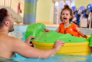 toddler on an aqua paddler in an indoor pool