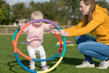 toddler playing with hula hoops