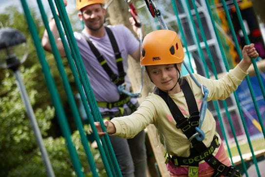 child on high ropes with parent