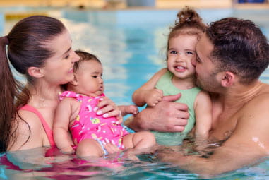 family with toddlers in indoor pool