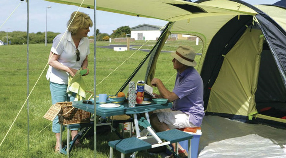 couple making a meal outside tent
