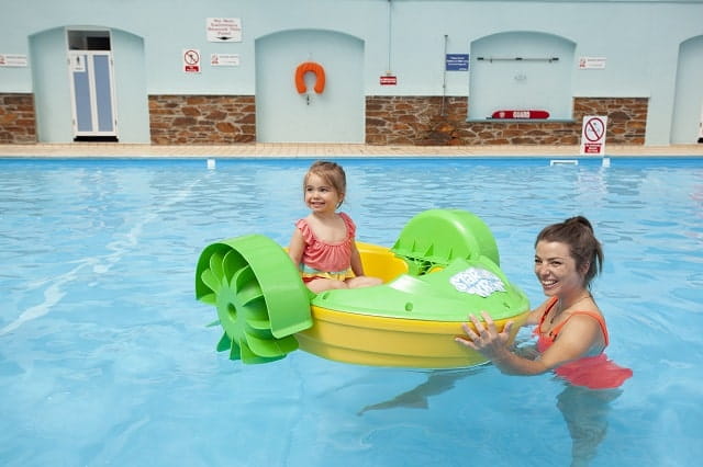 Mother playing with daughter on an aqua paddler in the indoor swimming pool