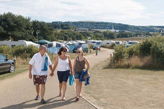 A family walking through the Touring and Camping site at Lower Hyde