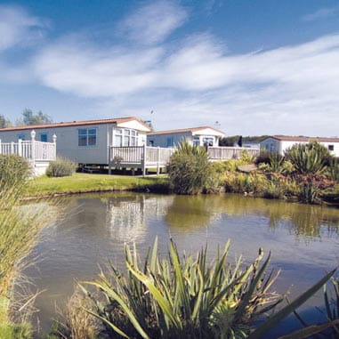 Park Dean caravans sitting behind a small lake