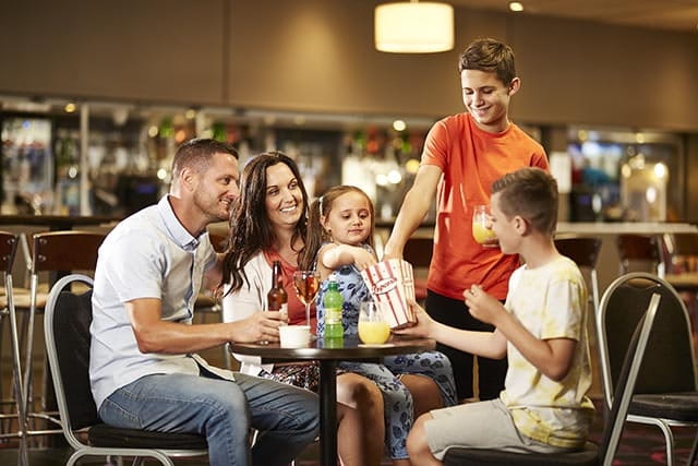 Family enjoying a meal in restaurant at Manor Park Holiday Park