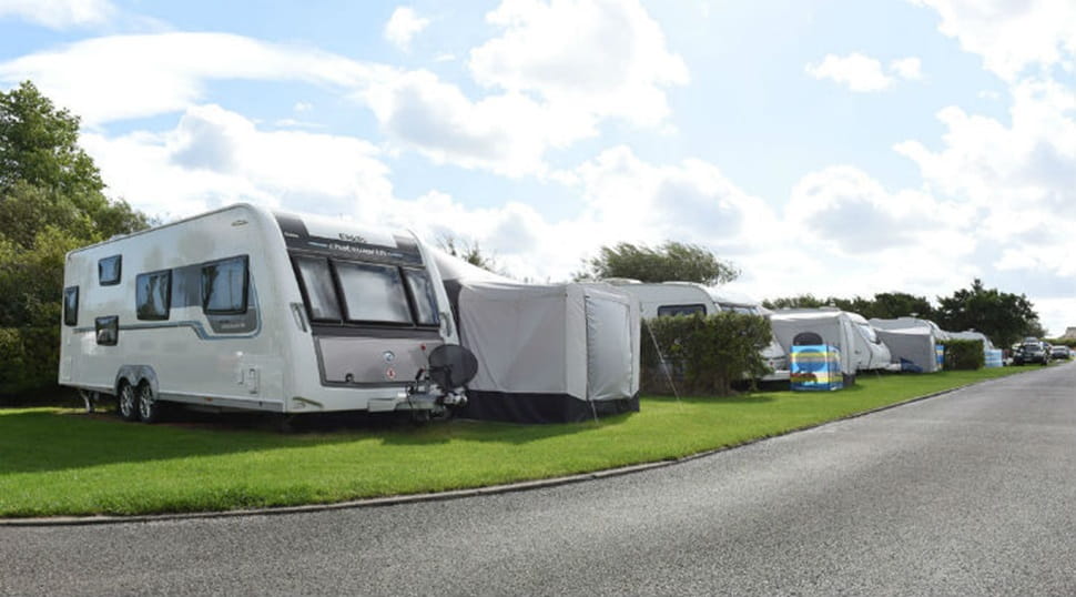 Touring caravans pitched up on the grass at Nairn Lochloy Holiday Park