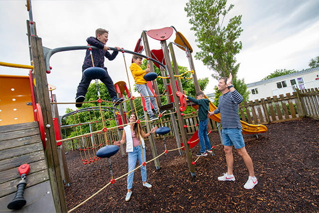 A family playing on the outdoor play area at Nairn Lochloy Holiday Park