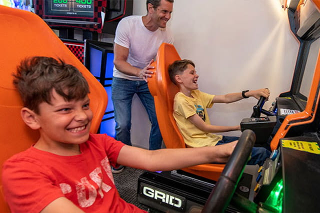 A dad and kids having fun in the amusement arcade