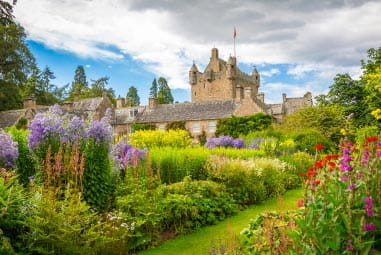 Cawdor Castle amongst a lush, colourful garden 