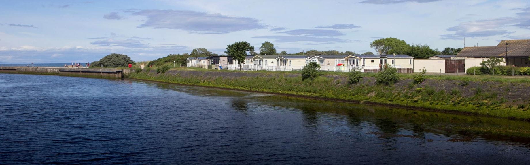 Deep blue loch bordered by white lodges
