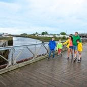 Family walking across a wooden bridge