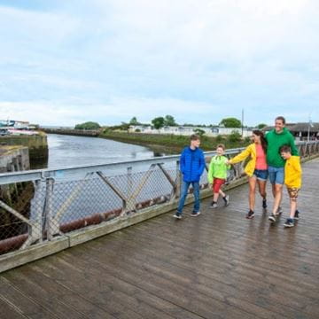 Family walking across a wooden bridge