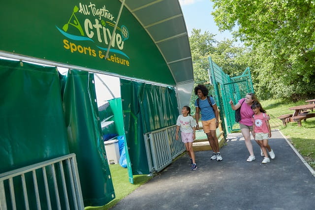 A family entering the activities hub at Naze marine Holiday Park