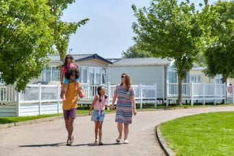 Family walking hand in hand through Parkdean Resorts