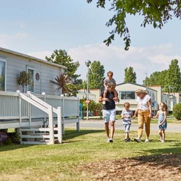 Family walking hand in hand through parkdean
