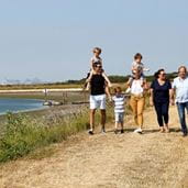 Family walking hand in hand through parkdean