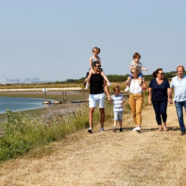 Family walking hand in hand through parkdean