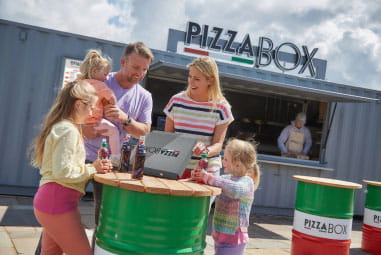 A family eating pizza outside