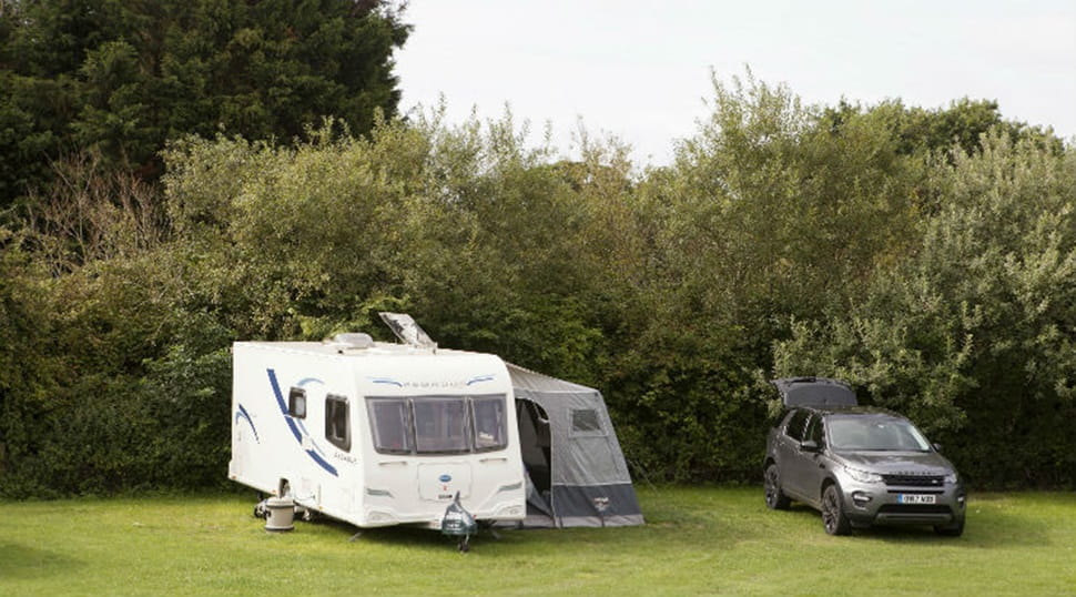 A touring caravan and awning pitched up on the grass