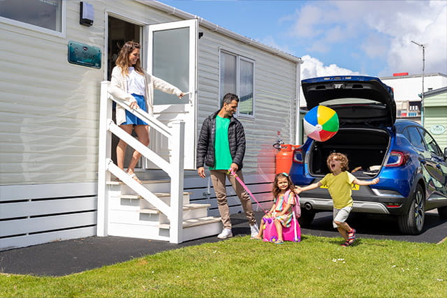 A family unpacking the car into their holiday accommodation at Ocean Edge Holiday Park