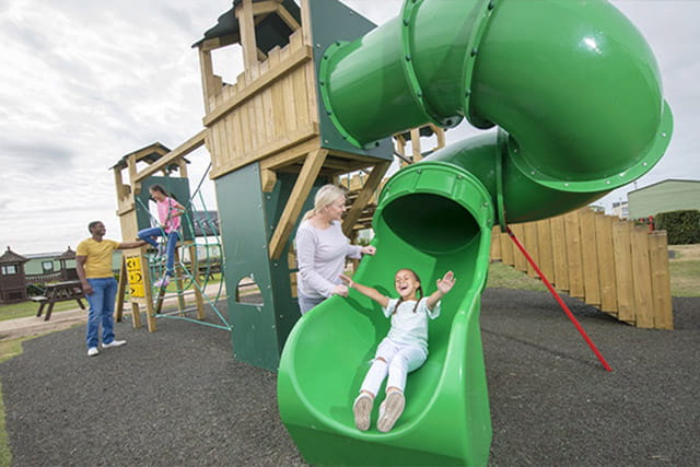 A child sliding down the slide at the adventure playground